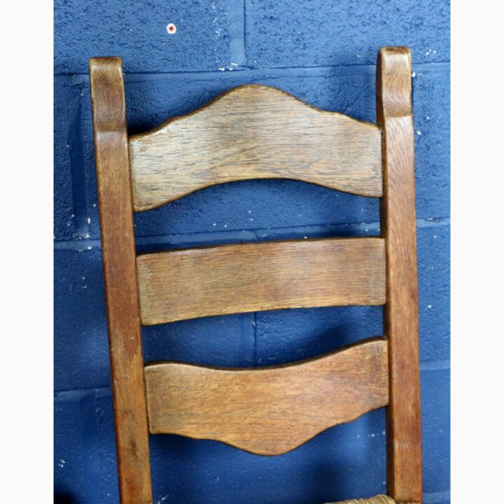 A Rustic Solid Oak Trestle Dining Table along with Set of Four Ladder Back Rush Seat Dining Chairs - Image 5