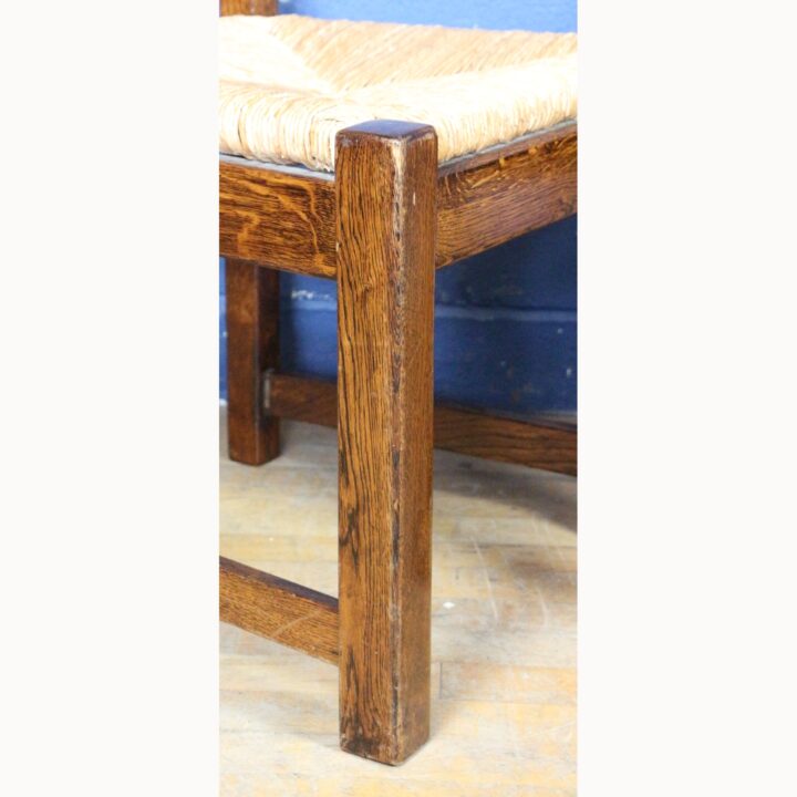 A Rustic Solid Oak Trestle Dining Table along with Set of Four Ladder Back Rush Seat Dining Chairs - Image 3