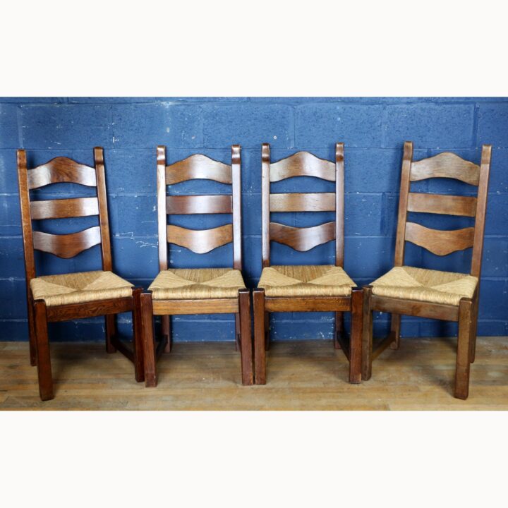 A Rustic Solid Oak Trestle Dining Table along with Set of Four Ladder Back Rush Seat Dining Chairs - Image 8