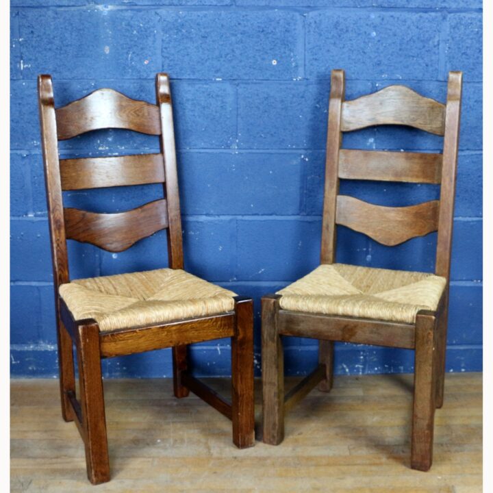 A Rustic Solid Oak Trestle Dining Table along with Set of Four Ladder Back Rush Seat Dining Chairs - Image 7