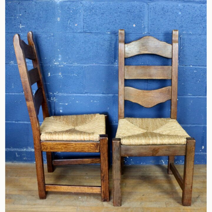 A Rustic Solid Oak Trestle Dining Table along with Set of Four Ladder Back Rush Seat Dining Chairs - Image 6