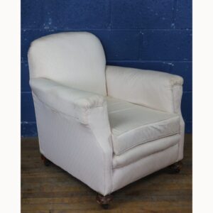 An Edwardian Deeply Padded Open Fireside Open Armchair, Raised on Bun Feet