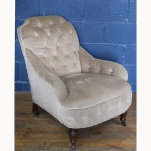 A C19th Country House Howard Style Deep Buttoned Armchair Raised on a Turned Supports.
