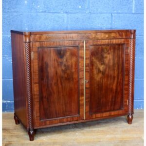 A Regency Mahogany Two Door Side Cabinet Raised on Turned Supports